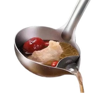A ladle pouring broth with goji berries and ginger.